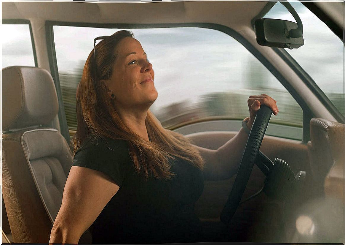 Woman checks the rear view mirrors with risk of accident in her car.