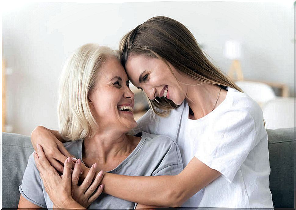 Daughter and mother hugging smiling.