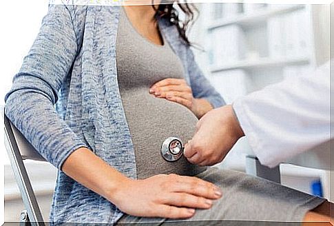 Pregnant belly being examined by a doctor.