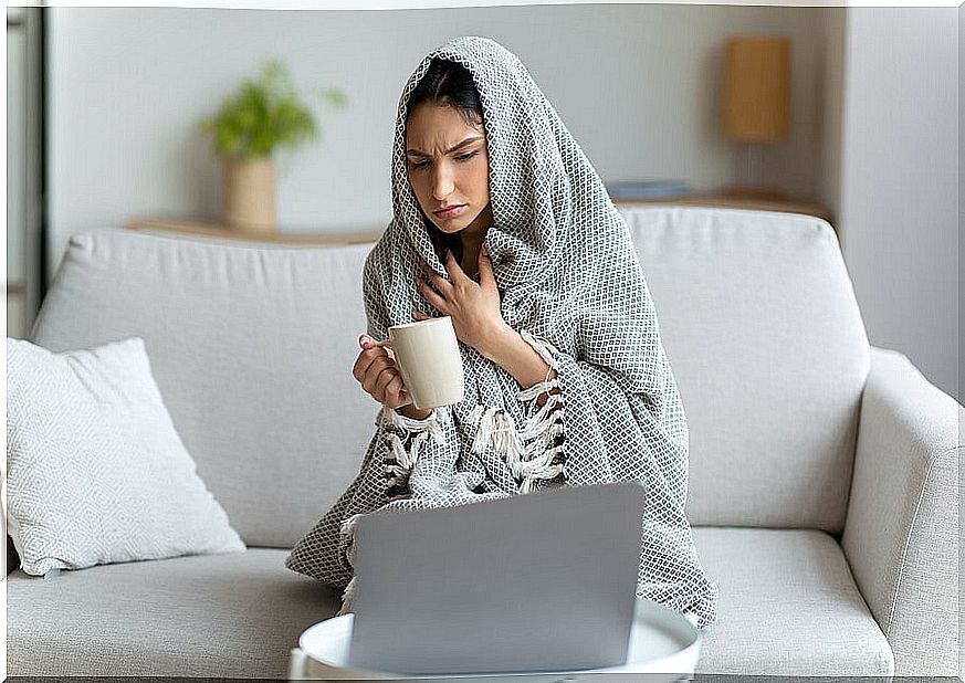 Woman wrapped in a blanket because of the cold.