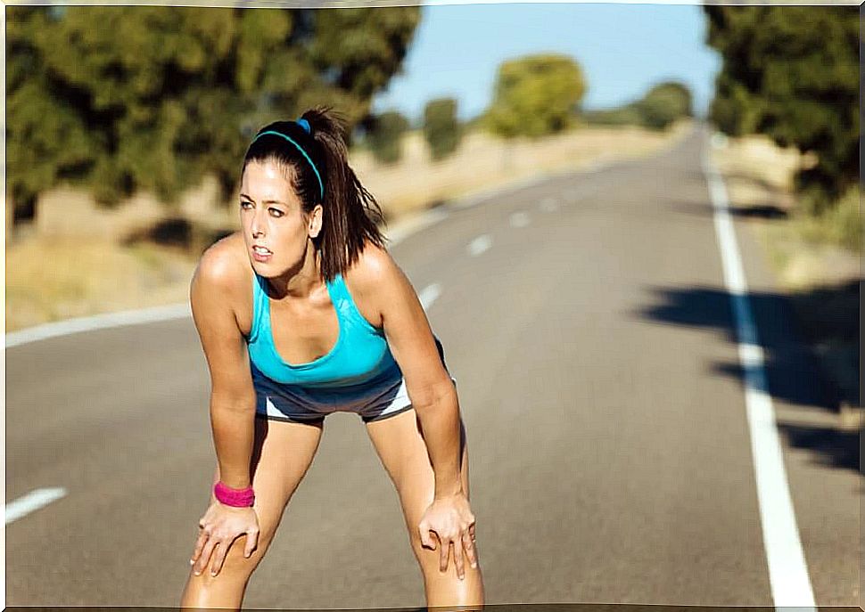 Tired woman sweating after running on road