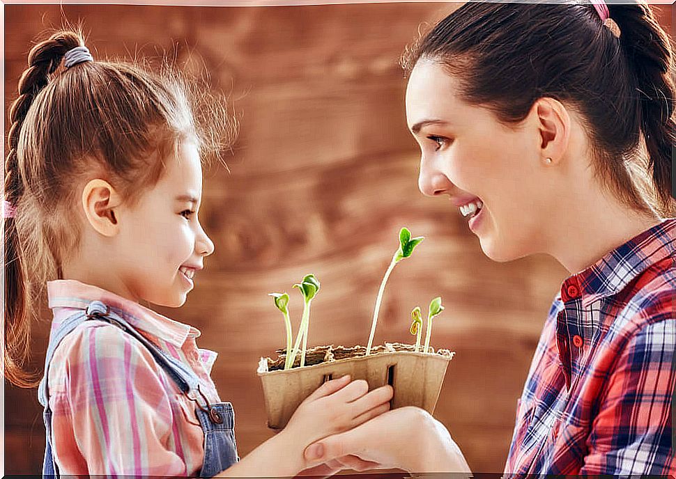 Super mom with her daughter holding flower pots