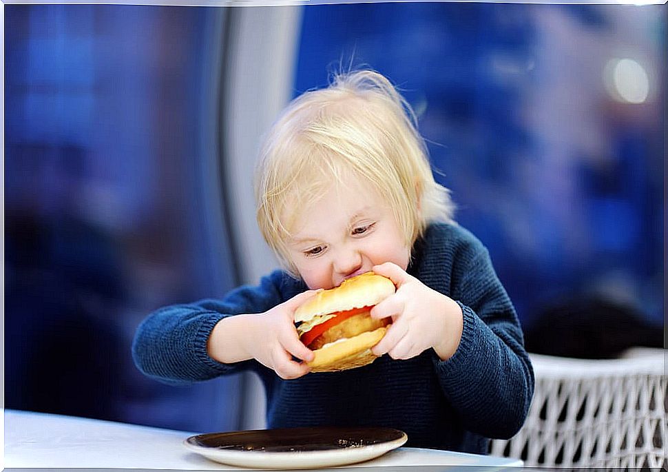 Boy biting a hamburger