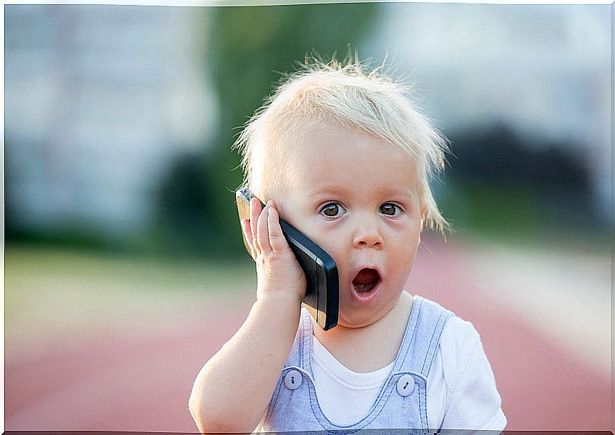 Little boy playing talking on a mobile phone.