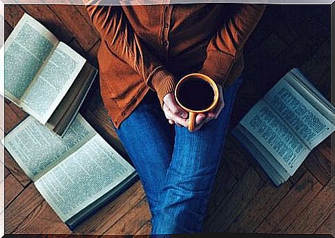 Woman-drinking-coffee-sitting-on-the-floor-with-books